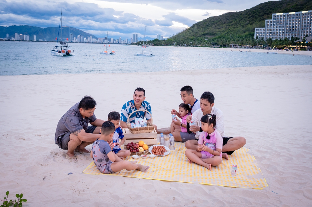 Các bố con quây quần bên bữa picnic giản dị ngay trên bờ cát