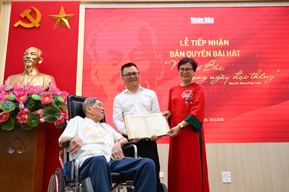 Tổng Biên tập Lê Quốc Minh nhận cuốn sổ ghi bài hát của nhạc sĩ Phạm Tuyên từ gia đình nhạc sĩ. (Ảnh: Thành Đạt)