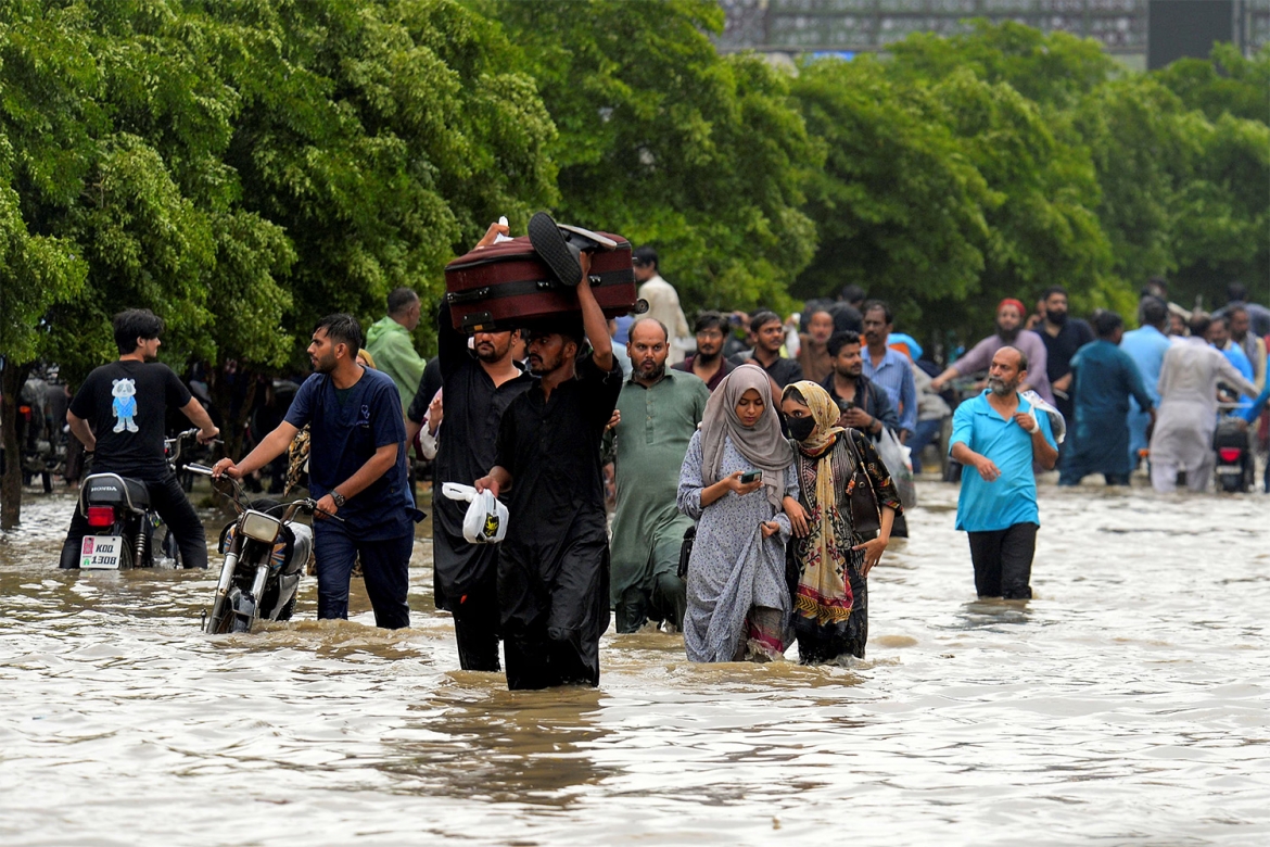 Người dân lội qua đoạn đường ngập sau trận mưa gió mùa tại thành phố Karachi, Pakistan, ngày 19/8/2025. Ảnh: Reuters
