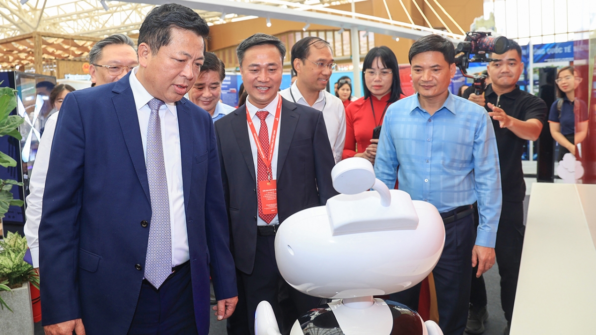 Bộ trưởng Trần Hồng Minh và Thứ trưởng Nguyễn Việt Hùng nghe giới thiệu về robot lễ tân E1 với khả năng cung cấp thông tin nhanh chóng - chi tiết - chính xác tại gian trưng bày của Bộ Xây dựng.