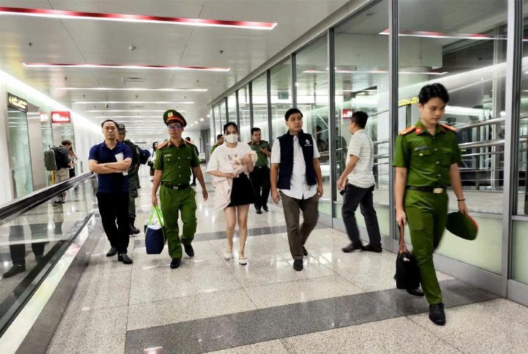 Ngô Thị Thêu (bế con nhỏ) bị dẫn giải về nước. Ảnh: Bộ Công an