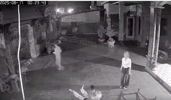 Hình ảnh Hà Thị Lai Hạ (áo trắng) nhìn chồng gục ngã dưới sân vẫn tỏ thái độ tức tối, mắng nạn nhân.