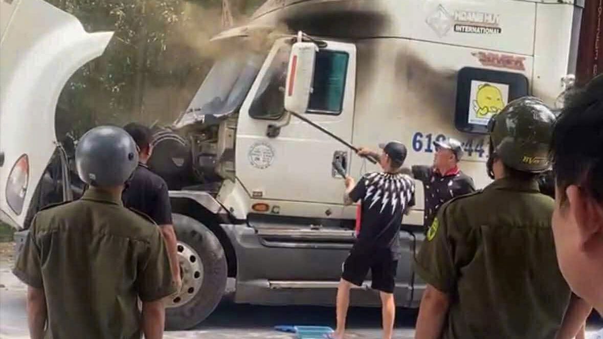 Người dân và lực lượng chức năng cạy cửa xe đưa người đàn ông ra ngoài 