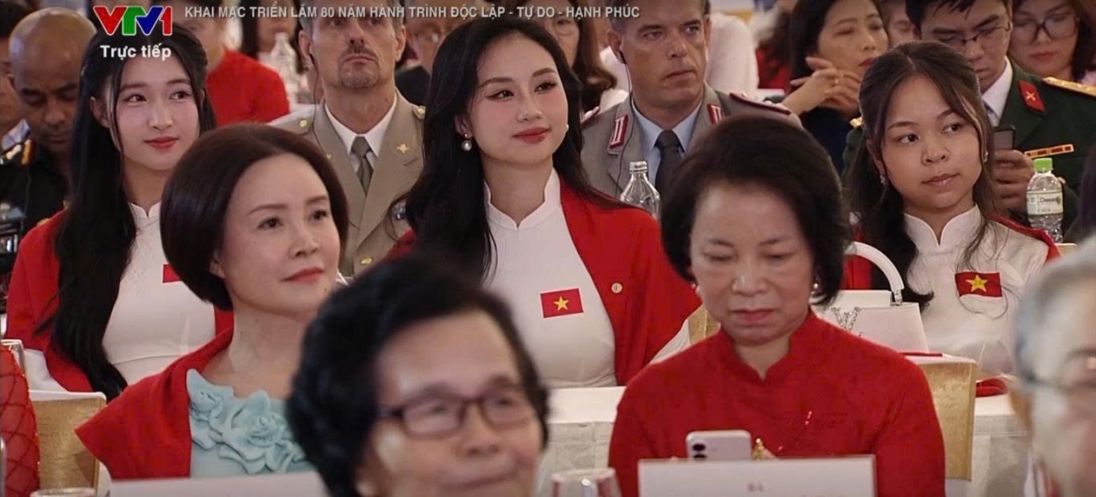 Á hậu Phương Nhi (góc trái) xuất hiện cùng các thành viên gia đình chồng tại khai mạc Triển lãm 80 năm thành tựu đất nước được tổ chức tại Trung tâm Triển lãm Việt Nam (Đông Anh, Hà Nội). Buổi tường thuật lễ khai mạc được phát sóng trực tiếp trên sóng truyền hình. Khoảnh khắc Phương Nhi xuất hiện trên truyền hình nhanh chóng gây sốt mạng xã hội. (Ảnh chụp màn hình).