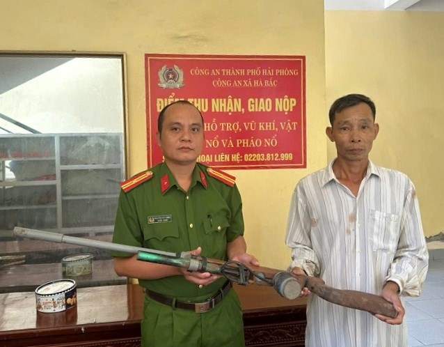 Công an xã Hà Bắc tiếp nhận khẩu súng từ ông Nguyễn Đức Sáng (Ảnh: Công an Hải Phòng)