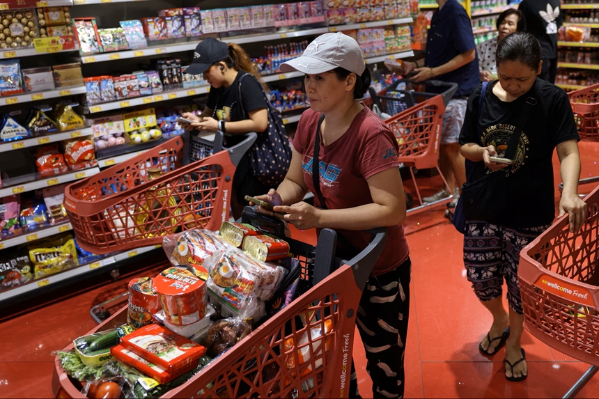Người dân đổ xô tích trữ nhu yếu phẩm, khiến siêu thị cháy hàng sữa và rau củ bị bán với giá gấp ba lần... Ảnh: Reuters