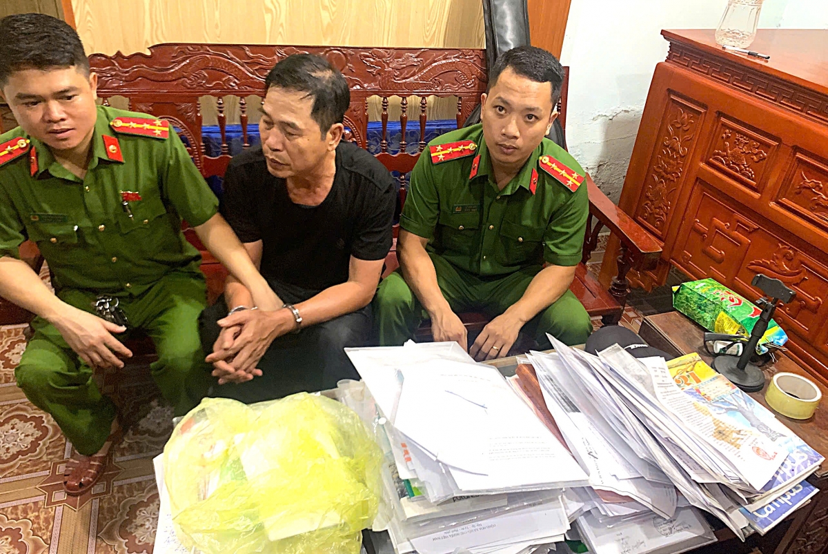 Đối tượng Ngô Trí Cường (áo đen) cùng một số tài liệu liên quan