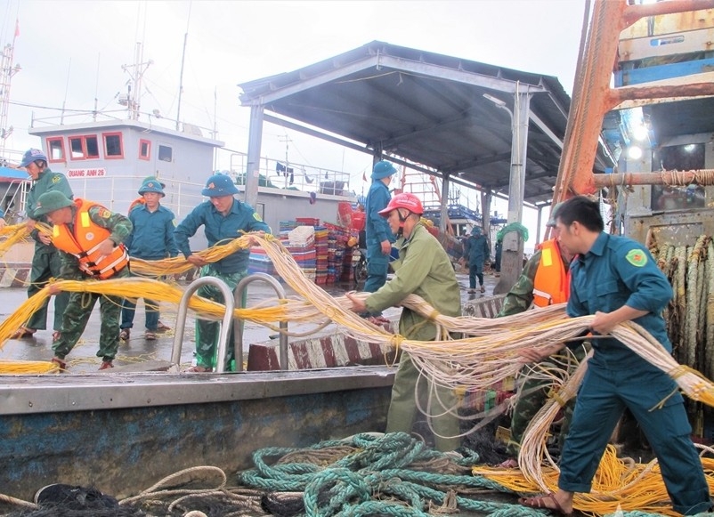Giúp dân chằng néo tàu thuyền (Ảnh QĐND)