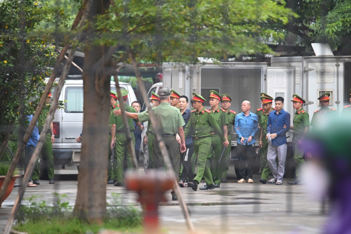 Các bị cáo được áp giải đến tòa dưới sự kiểm soát an ninh nghiêm ngặt của lực lượng cảnh sát. (Ảnh: T.H)
