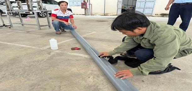 Các đối tượng đang tẩy dòng chữ trên ống nhựa của hãng Tiến Phương để phun lên dòng chữ Tiền Phong.