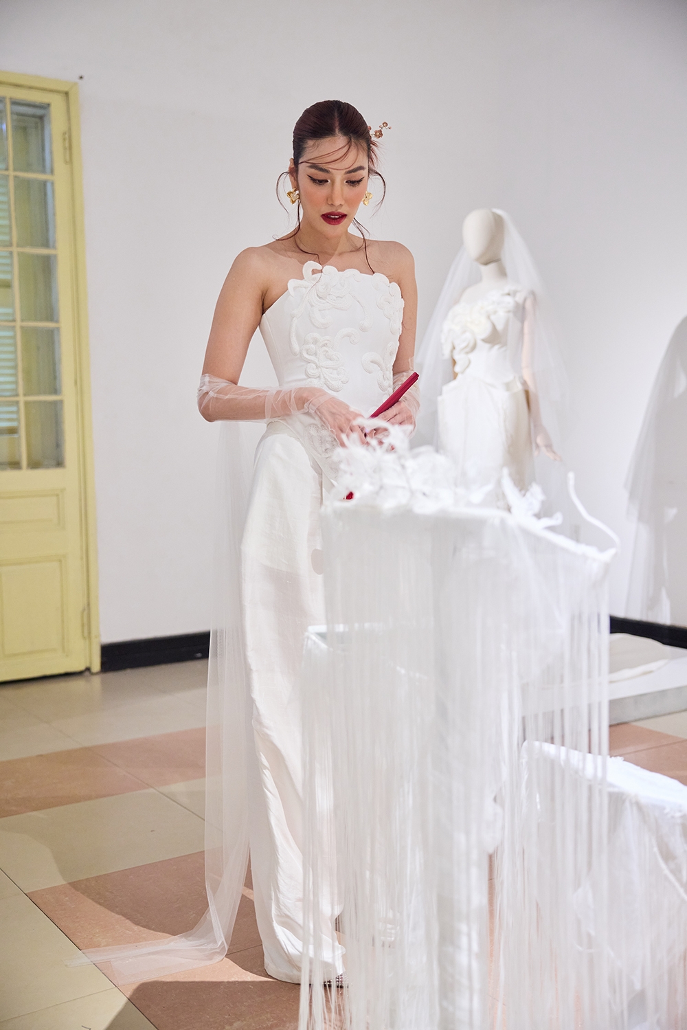 Siêu mẫu Lan Khuê chiêm ngưỡng các tiêu bản thêu được trưng bày tại triển lãm.