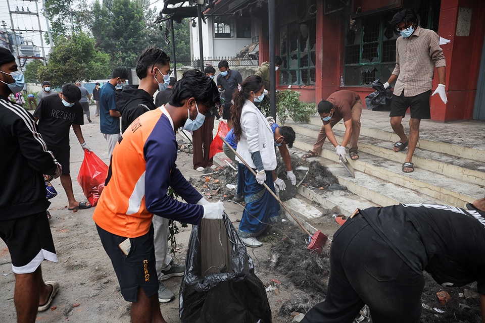 Người dân dọn dẹp khuôn viên trụ sở Cục Quản lý Giao thông sau các cuộc biểu tình.
