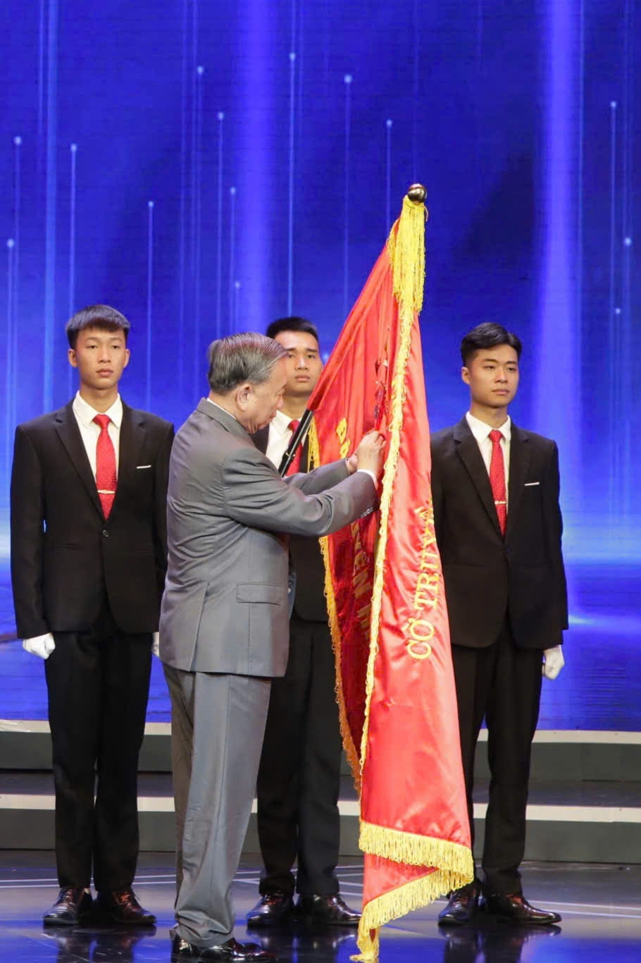 Tổng Bí thư Tô Lâm gắn Huân chương Lao động hạng Nhất lên lá cờ truyền thống của Đài Truyền hình Việt Nam. Ảnh: VTV