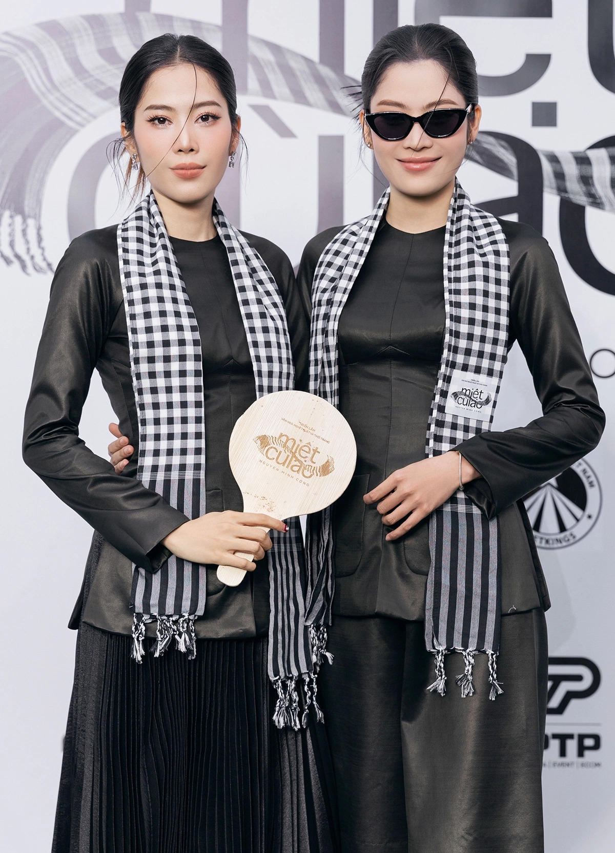 Hoa khôi Nam Em cùng chị song sinh Nam Anh diện áo bà ba, quàng khăn rằn, khoe sắc bên dàn sao tại sự kiện.