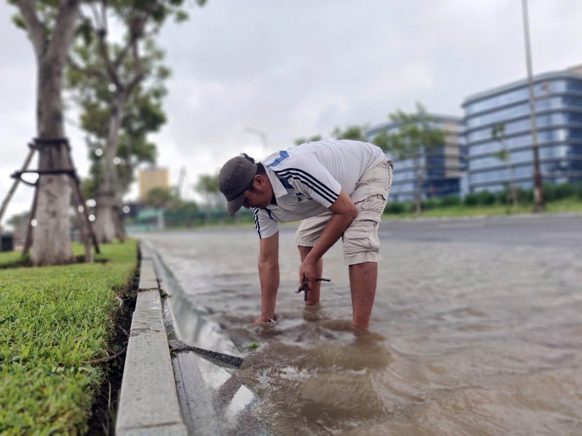 Người dân khơi thông cửa thoát nước chống ngập