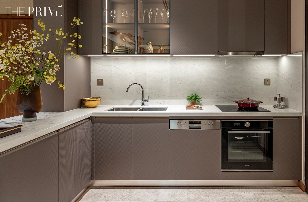 Khu vực bếp – trái tim của căn hộ - sử dụng đá quartz kết hợp cùng loạt thiết bị bếp cao cấp được lắp âm (built-in) đảm bảo tính thẩm mỹ lẫn công năng sử dụng