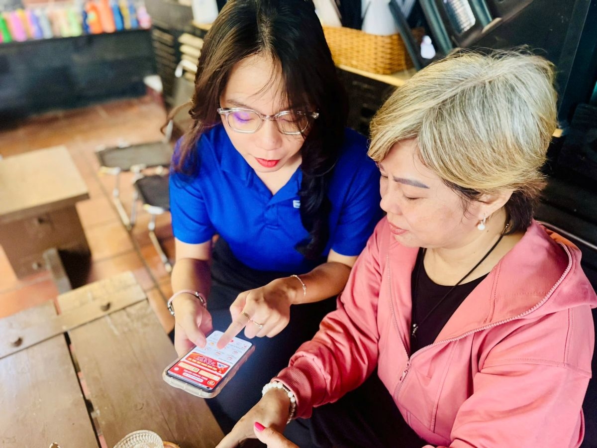 Thành viên đội xung kích "đi từng ngõ, gõ từng nhà" giúp người dân nắm bắt công nghệ