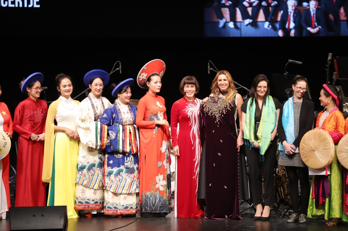 Tiến sĩ Phan Bích Thiện, Chủ tịch Hội Phụ nữ Việt Nam tại Hungary trao tặng nghệ sĩ Miklósa Erika một bộ áo dài Việt Nam được các nghệ nhân may thủ công tinh xảo.