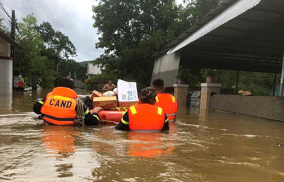 Các chiến sỹ công an dầm mình trong nước lũ cung cấp nhu yếu phẩm cho người dân bị cô lập.