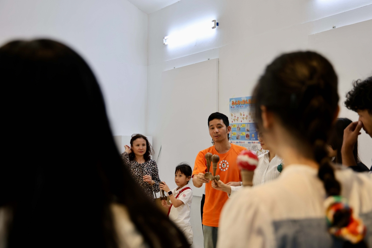Trò chơi dân gian Kendama thu hút đông đảo bạn trẻ tham gia, mang lại không khí vui tươi và tinh thần thi đấu thân thiện – một nét đặc trưng trong lễ hội Nhật Bản truyền thống. Kendama là đồ chơi kỹ năng truyền thống của Nhật Bản: một tay cầm gỗ (ken) có ba chén và một mũi nhọn, kèm quả bóng gỗ (tama) nối bằng dây. Người chơi tung bắt bóng lên các chén hoặc “cắm” vào mũi nhọn để thực hiện chuỗi kỹ thuật (trick), qua đó rèn phản xạ, thăng bằng và tập trung. (Ảnh: Trung tâm Giao lưu Văn hóa Nhật Bản tại Việt Nam)