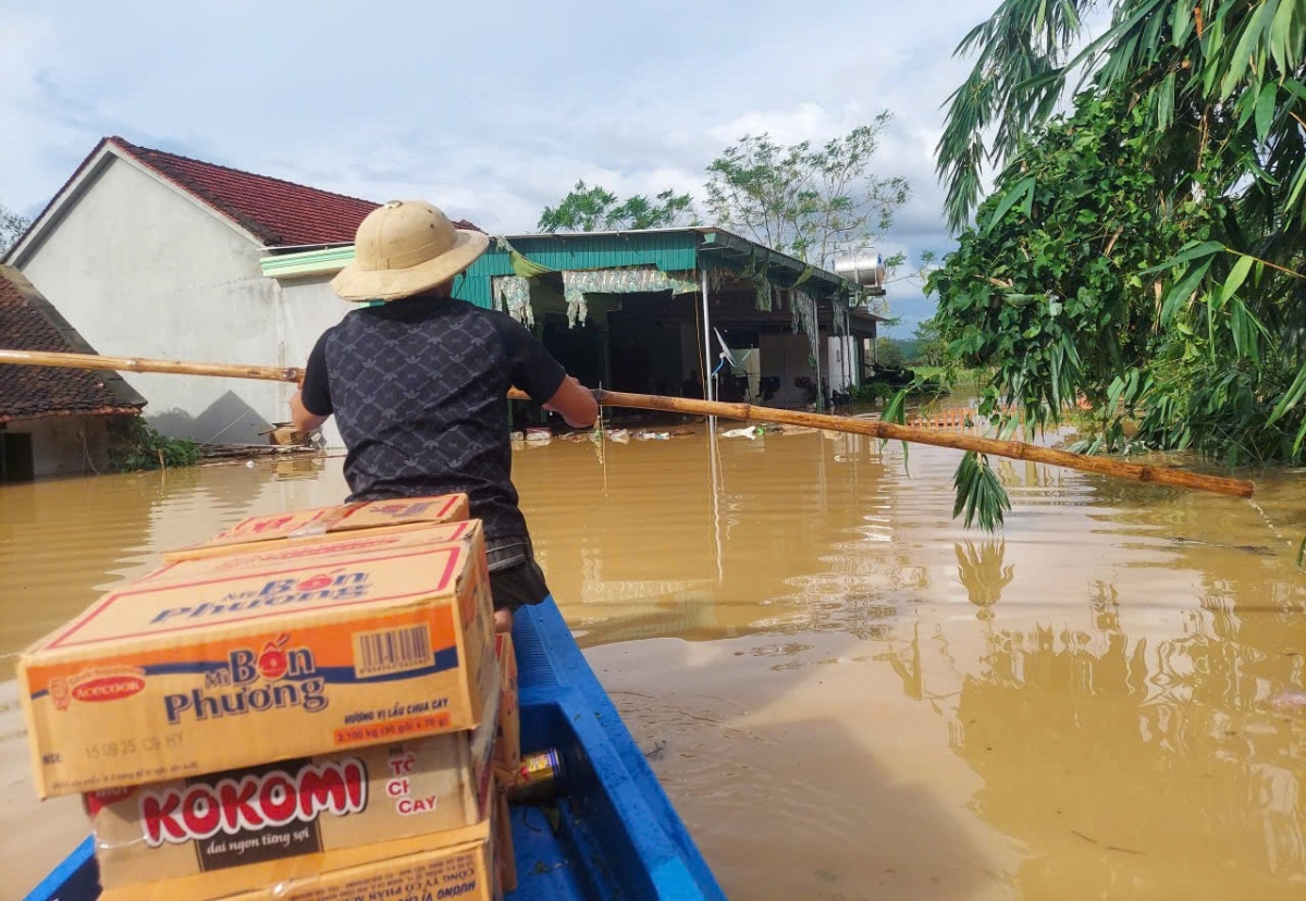 Dùng thuyền tiếp cận vùng cô lập để cứu trợ người dân tại xã Nghĩa Hành. Ảnh: KT.