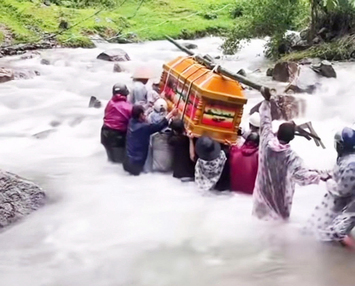 Người dân khiêng quan tài vượt qua suối đem đi chôn cất