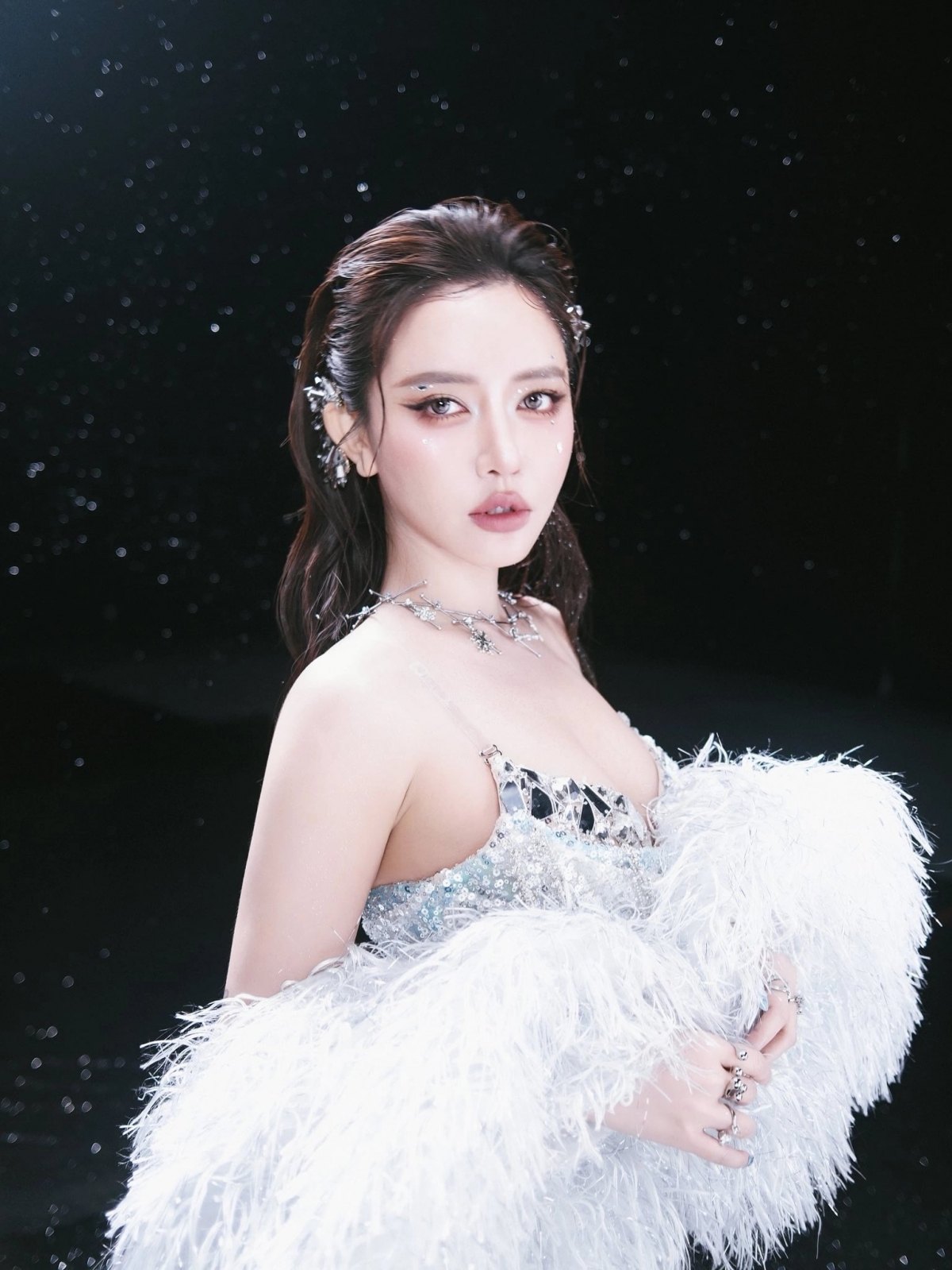 Ca sĩ Bích Phương xuất hiện với hình ảnh lấy cảm hứng từ nữ thần băng giá, mặc trang phục đính lông vũ và trang điểm tông lạnh, nhấn mạnh đôi mắt và bờ môi.