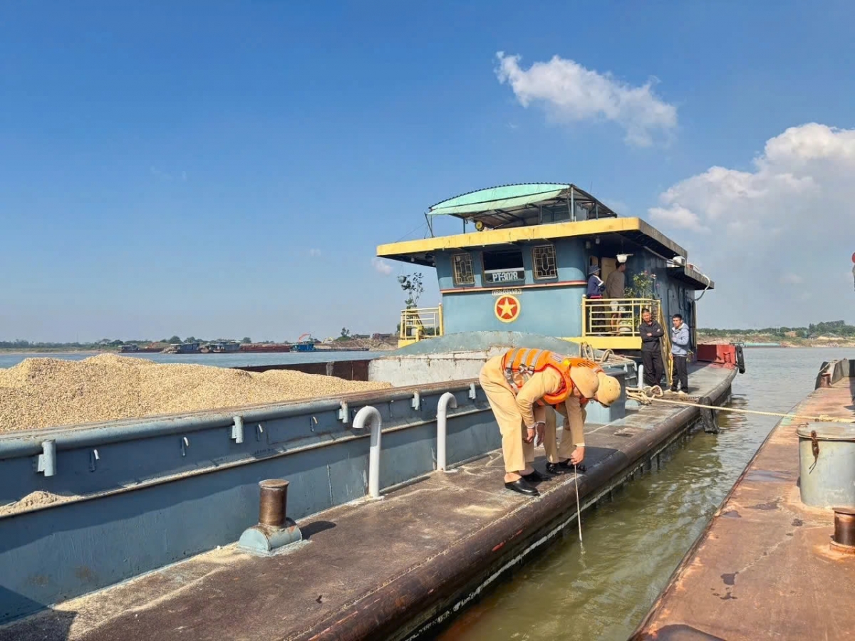 Đội CSGT đường thủy Phú Thọ kiểm tra việc chở hàng vượt quá vạch dấu mớn nước an toàn của phương tiện. 