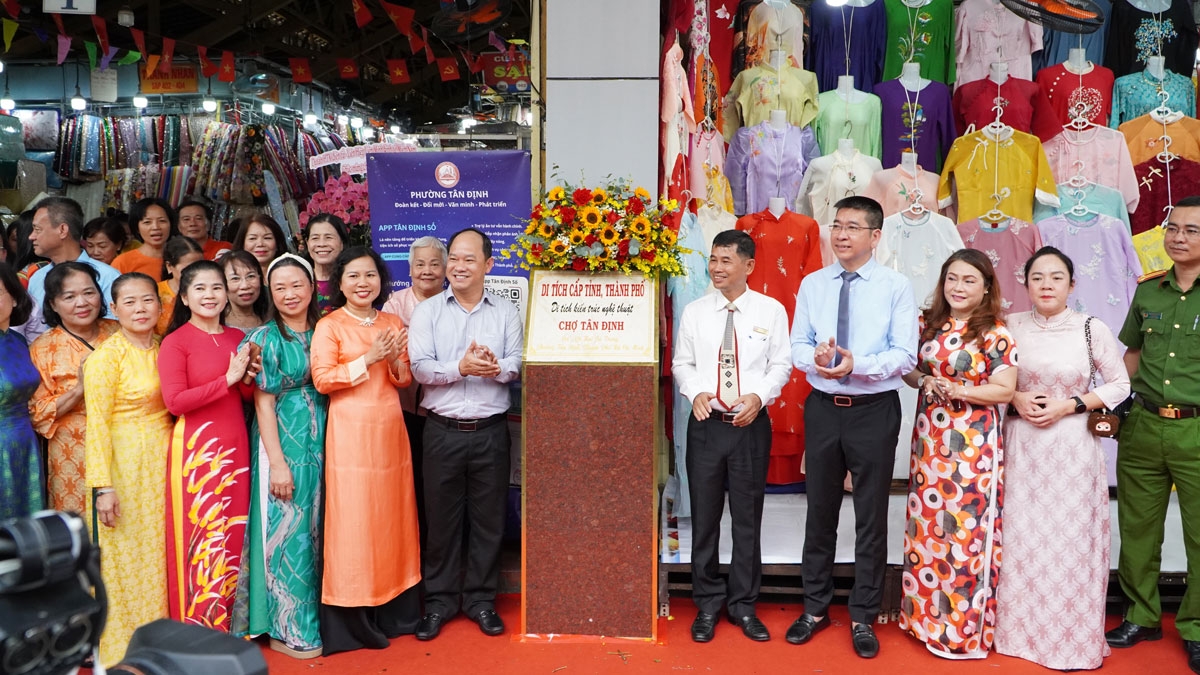 Lãnh đạo địa phương cùng ban quản lý chợ Tân Định và tiểu thương tham dự lễ gắn biển công nhận di tích kiến trúc nghệ thuật cấp tỉnh, Thành phố. (Ảnh: T.H)