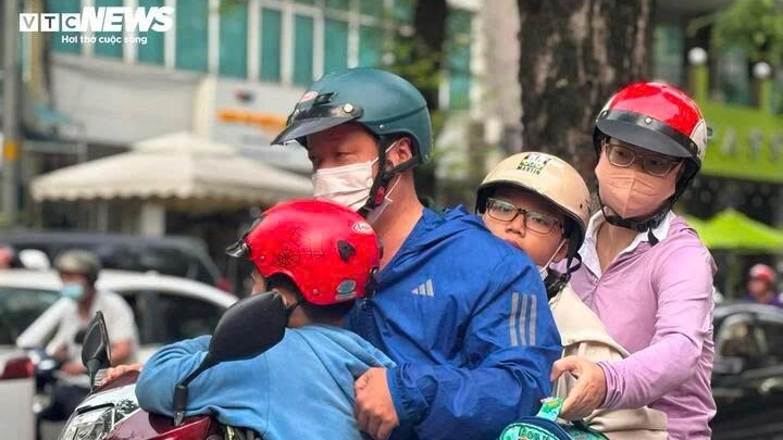 Nhiệt độ giảm mạnh, người dân TP.HCM co ro đi học, đi làm trong sáng sớm.
