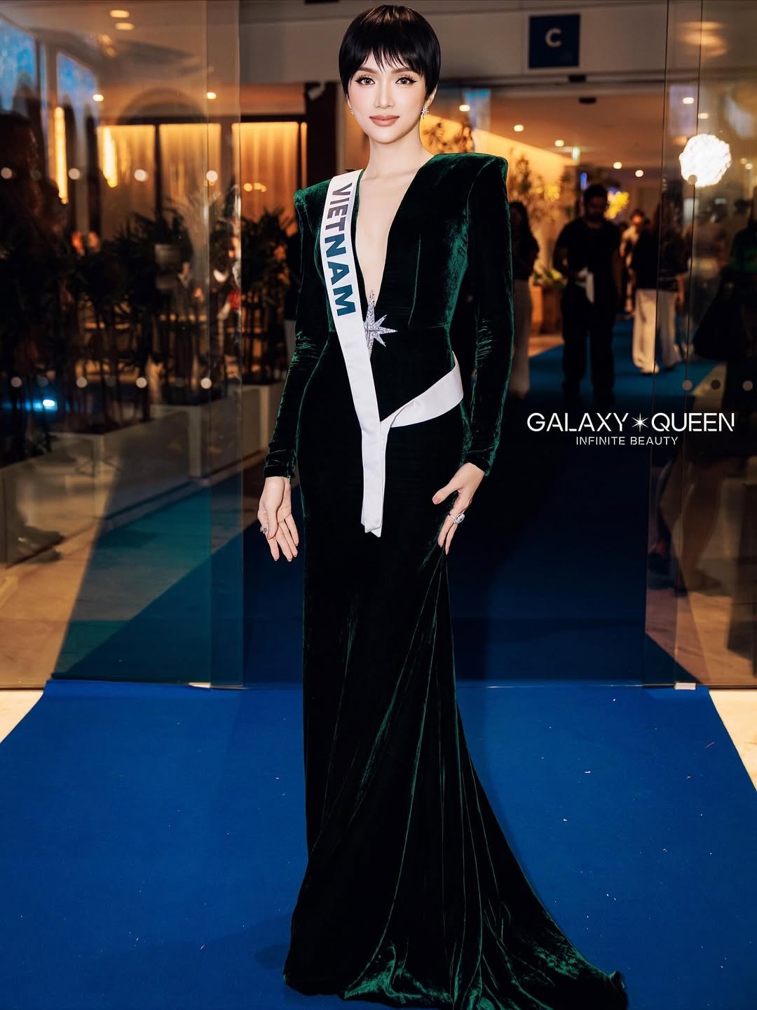 Trong tiệc tối ngày 8/11, Hương Giang xuất hiện với bộ đầm nhung màu xanh cổ vịt ôm sát, khoét sâu hình chữ V táo bạo, điểm nhấn là biểu tượng ngôi sao màu trắng đính kim cương. Hương Giang gây chú ý khi chọn tạo hình tóc ngắn khác lạ so với phong cách quen thuộc.