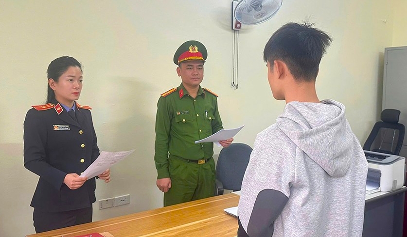 Lực lượng chức năng tống đạt quyết định khởi tố bị can đối với Nguyễn Đình Hiếu.