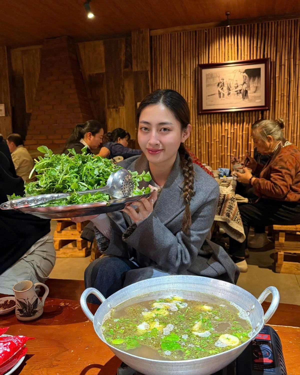 Hoa hậu Lương Thùy Linh tranh thủ thưởng thức đặc sản thắng cố khi đến Sa Pa dự show thời trang.