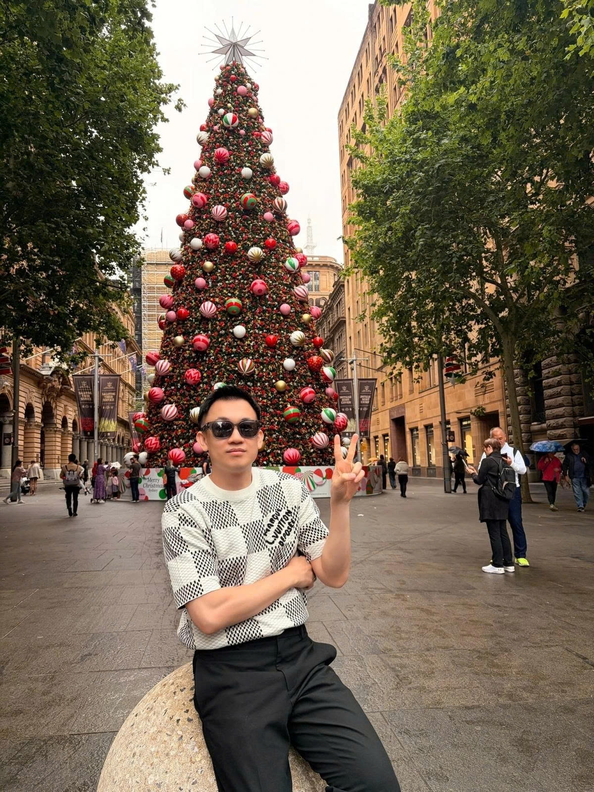 Ca sĩ Dương Triệu Vũ chụp ảnh cùng cây thông Noel tại Sydney, Australia.