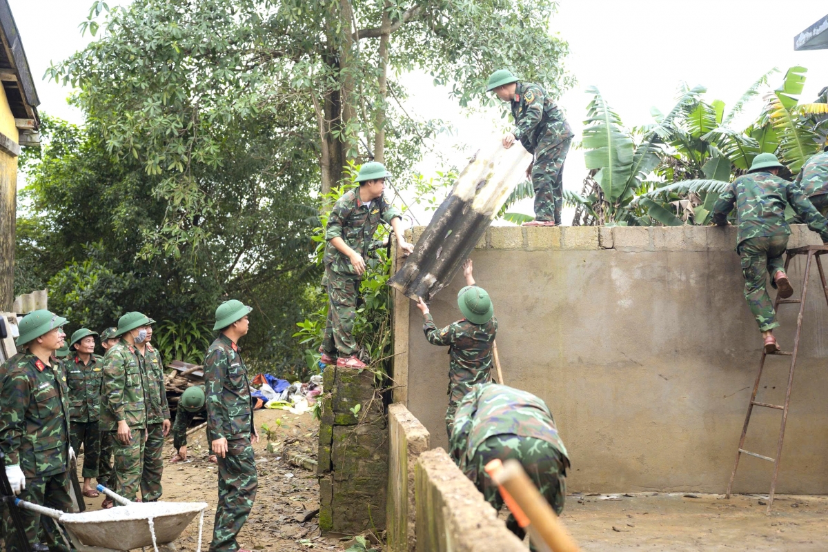 Bộ đội giúp dân sửa chữa lại nhà sau thiên tai