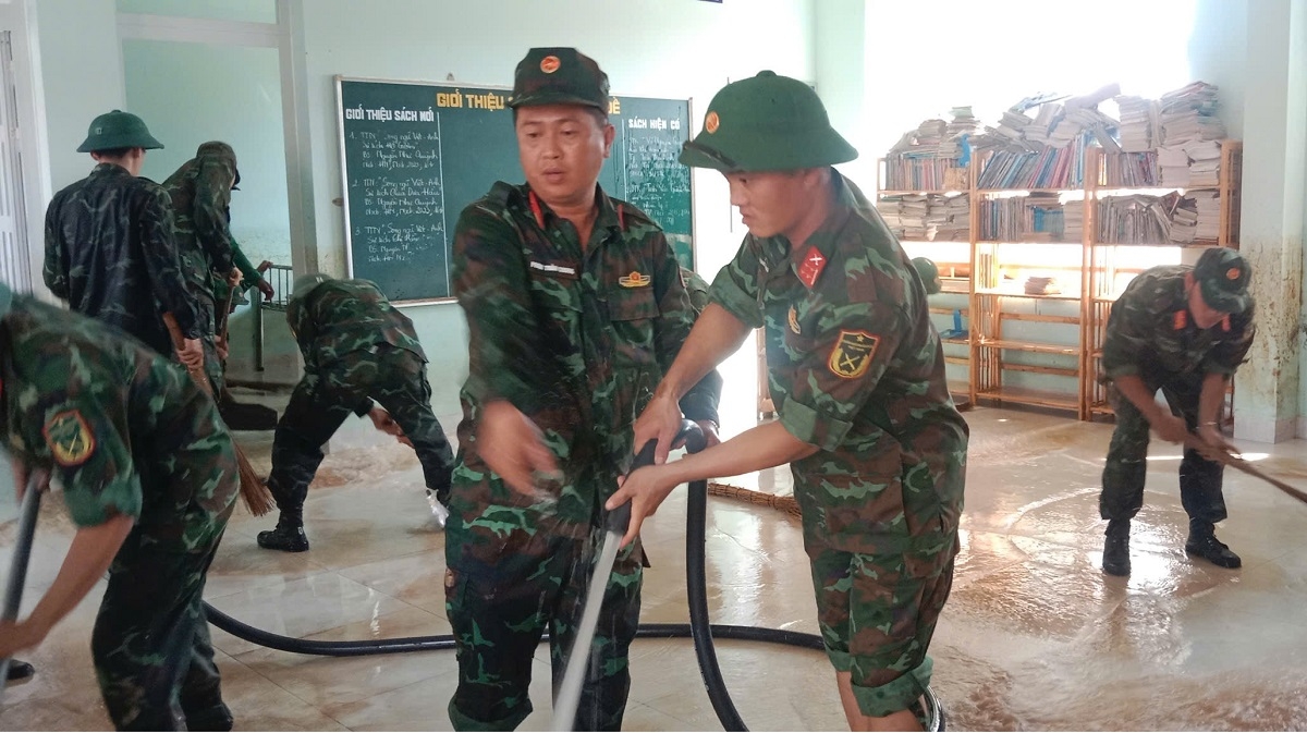 Lực lượng chức năng hỗ trợ nhà trường vệ sinh phòng học. Ảnh: N.T