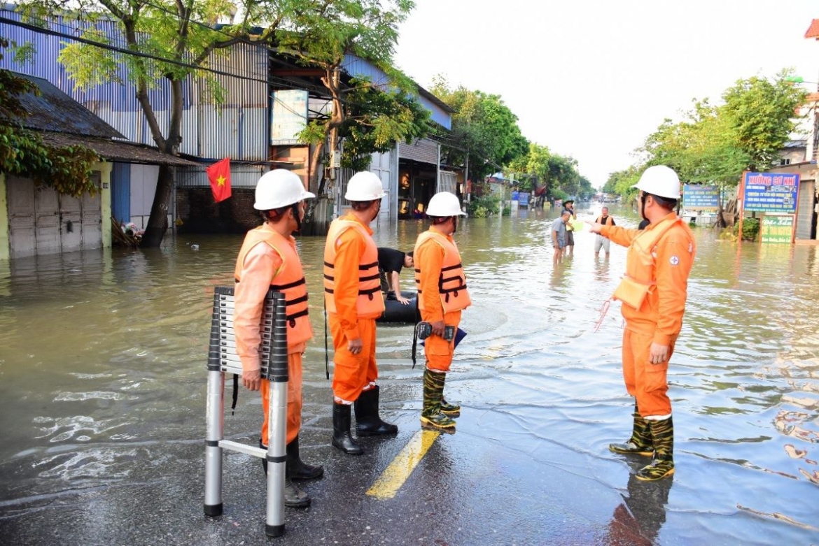 Công nhân EVNHANOI kiểm tra tình trạng lưới điện nơi ngập úng tại khu vực Sóc Sơn