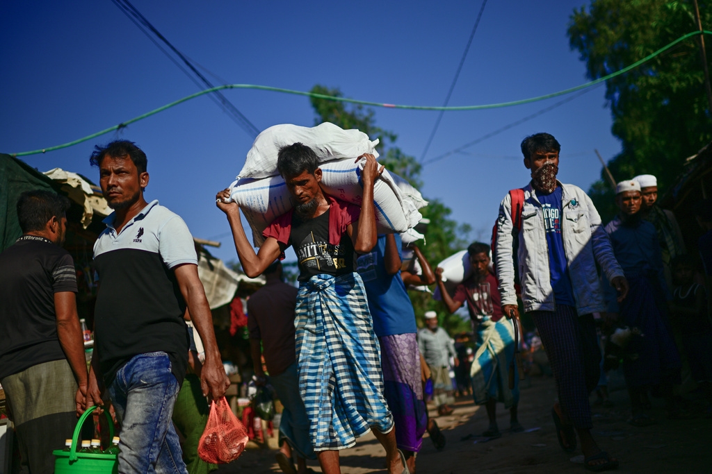Người tị nạn Rohingya đang mang theo khẩu phần ăn ít ỏi của gia đình mình khi nguồn viện trợ ngày càng bị cắt giảm.