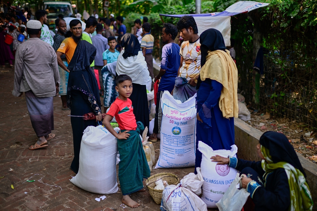 Người tị nạn Rohingya đang chờ đợi nhận những phần lương thực ít ỏi được phân phát cho gia đình trước khi mang về nhà.
