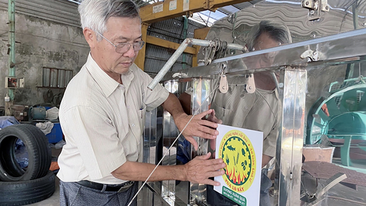 Ông Dương Xuân Quả với chiếc máy sấy do mình sáng chế. Ảnh KT