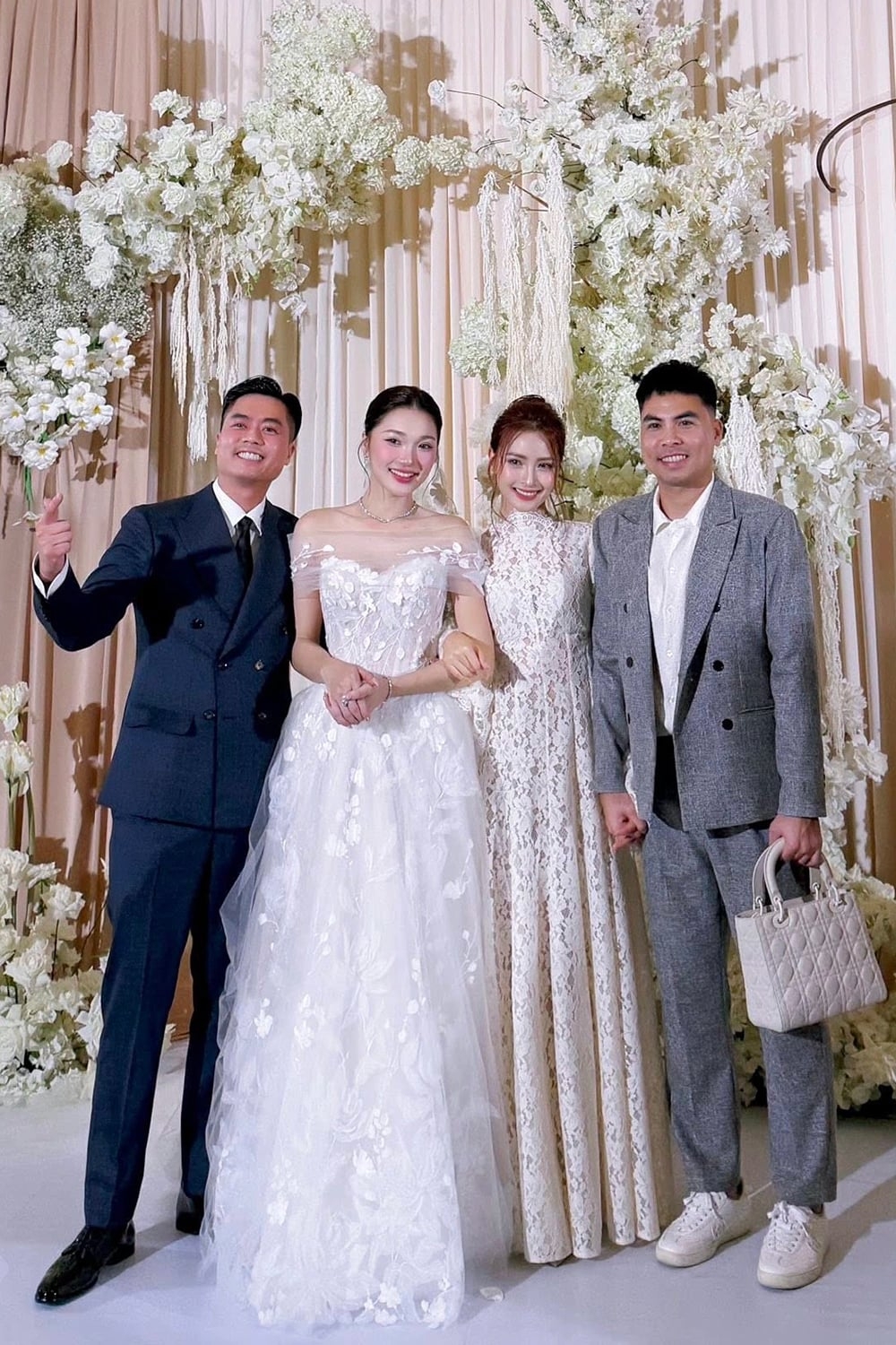 Đức Huy (bìa phải) xách túi cho vợ chưa cưới - MC Huyền Trang 'Mù Tạt' - khi cả hai dự đám cưới người đẹp Ngọc Nữ và chồng doanh nhân. Tiền vệ người Hải Dương được khán giả nhận xét ngày càng điển trai từ khi hẹn hò MC đài quốc gia. Anh cầu hôn cô hôm 27/11 nhưng cả hai chưa tiết lộ ngày cưới.