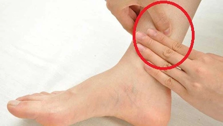 Dùng 1 tay giữ cổ chân, 1 tay day huyệt với lựa vừa đủ.