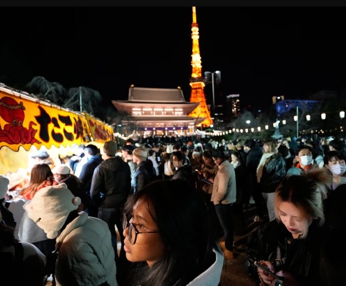 Người dân tập trung chào đón năm mới tại chùa Zojoji ở Tokyo ngày 31/12. Ảnh: AP