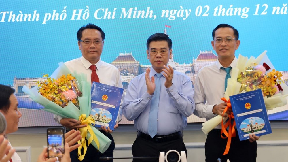 Phó Chủ tịch UBND TP.HCM Nguyễn Văn Dũng trao Quyết định điều động ông Trương Công Huy (phải) và ông Phan Tấn Thảo (trái) (ảnh: Hà Trang/Cổng thông tin TP.HCM)