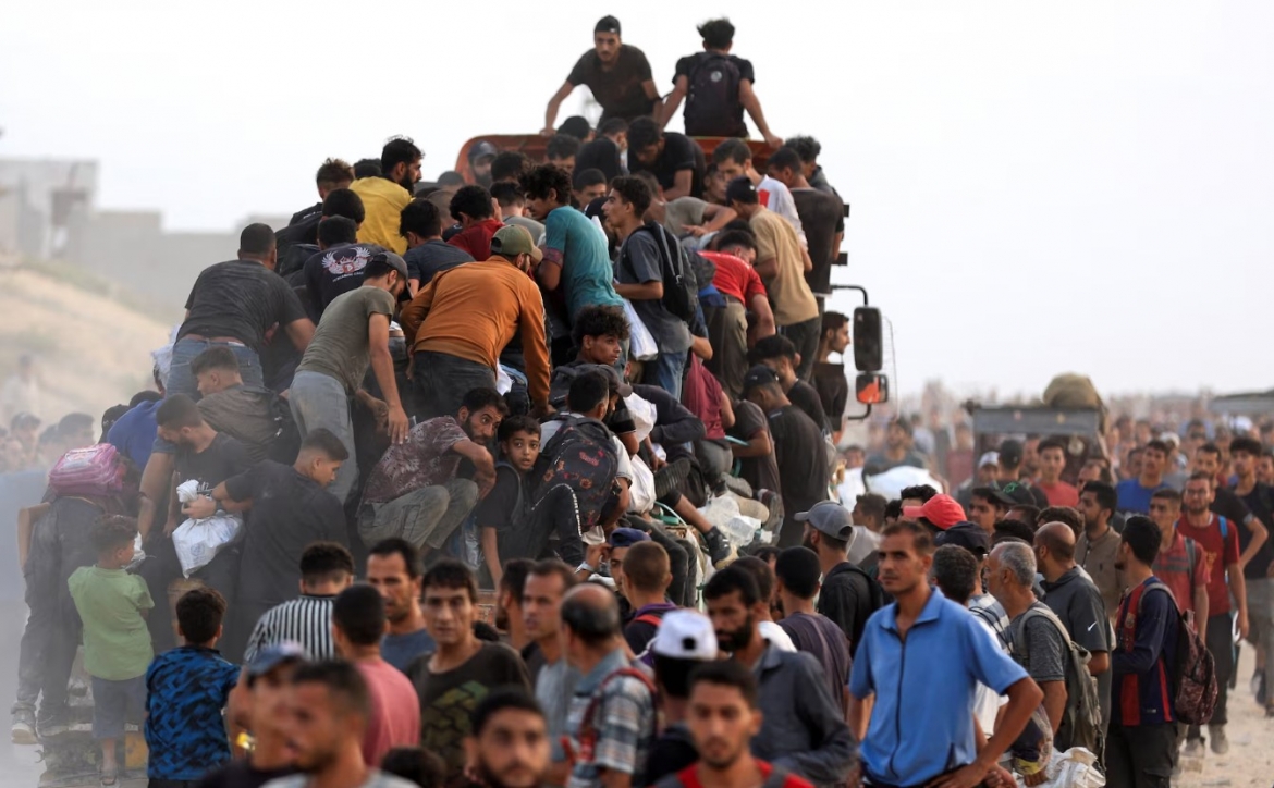 Người dân Gaza lũ lượt trèo lên xe cứu trợ để tranh giành hàng tiếp tế. Ảnh: Reuters