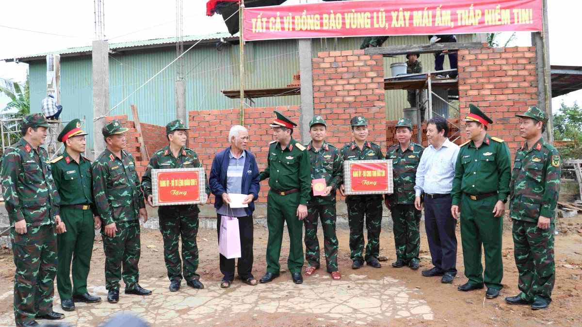 Trung tướng Lê Ngọc Hải (thứ 6, từ trái qua) tặng quà hộ dân được Lữ đoàn 572 hỗ trợ xây nhà giúp dân.