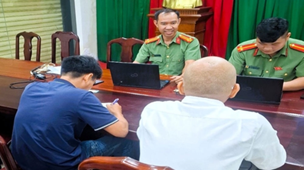 Ông D.M.T (áo thun xanh bên trái) cùng người nhà làm việc tại cơ quan công an (ảnh: CA)