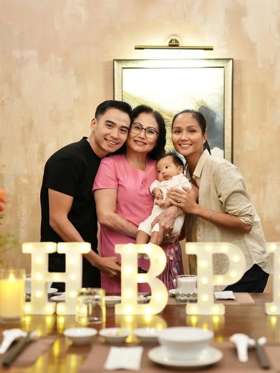 Hoa hậu H'hen Niê cùng ông xã Tuấn Khôi đưa con gái ba tháng tuổi, bé Harley, đến tiệc mừng tuổi mới của mẹ chồng. Người đẹp để mặt mộc, ăn mặc đơn giản khi dự tiệc.