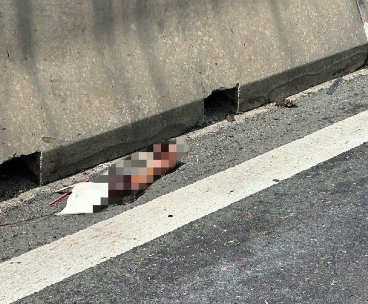 Một cánh tay người nằm sát dải phân cách. Ảnh: B.H