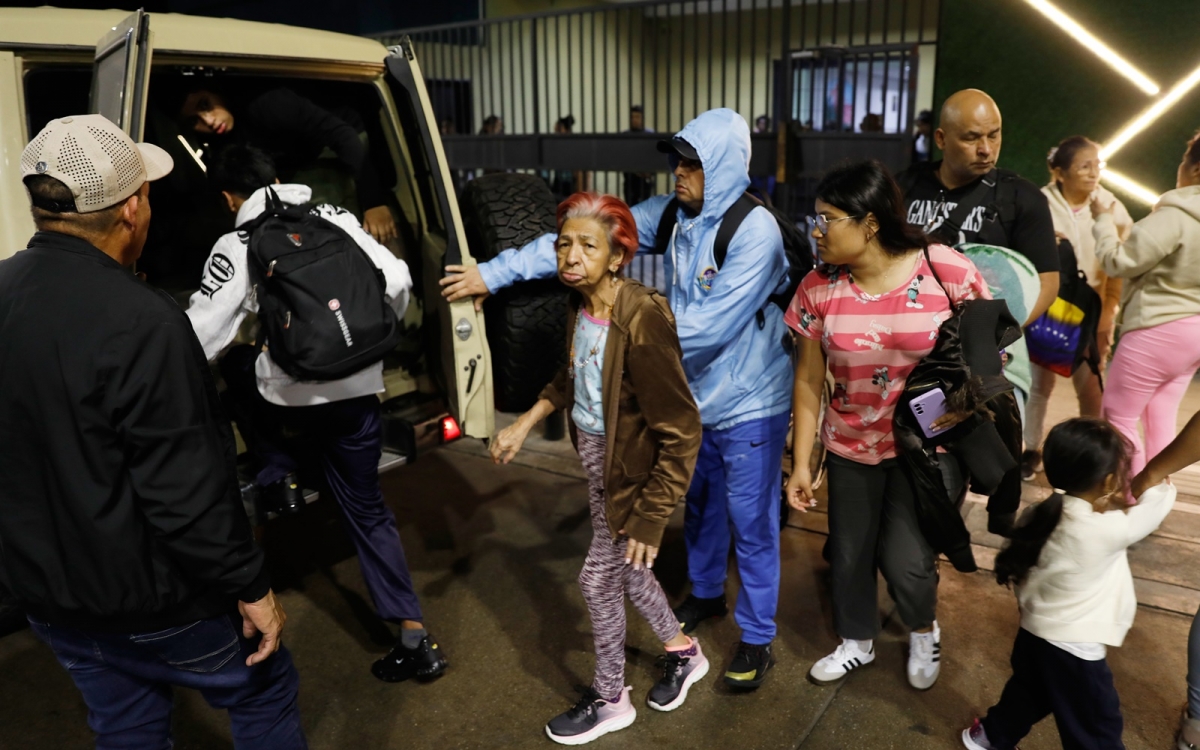 Cư dân Venezuela sơ tán khỏi một tòa nhà gần dinh tổng thống Miraflores. Ảnh: AP.